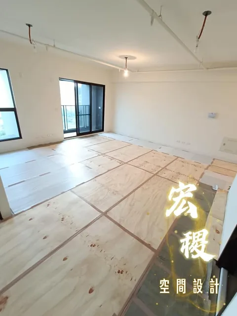 室內地面鋪設保護板，牆面與採光窗已可見。