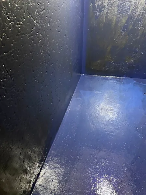 狹長空間的牆面與地坪可見深色、藍色塗層。