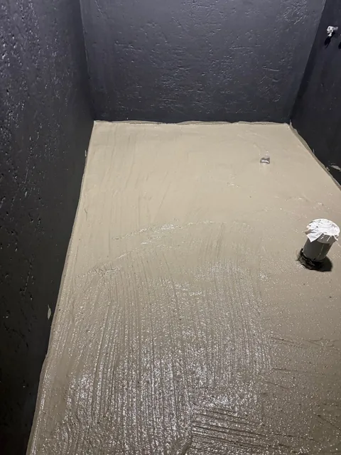 深色牆面塗層與淺色地坪收整的施工畫面。