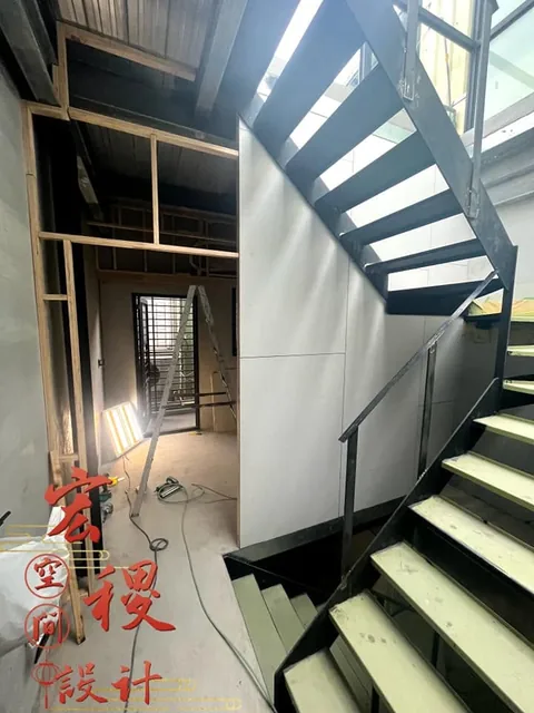 黑色樓梯與周邊仍在施作的室內結構。