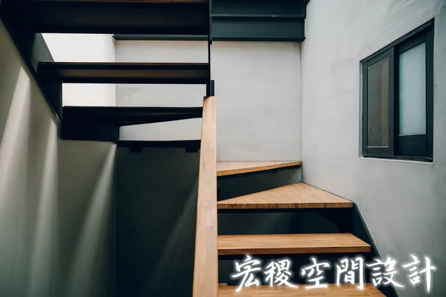 木踏板與扶手的近距離樓梯畫面。