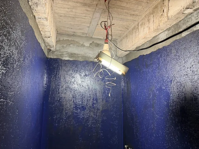 牆面深藍色塗層與裸露天花的施工畫面。