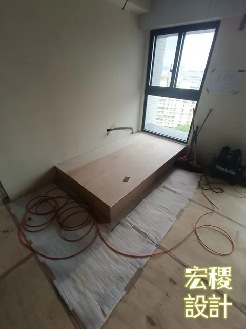 窗邊木床台施工，可見工具與延長線。