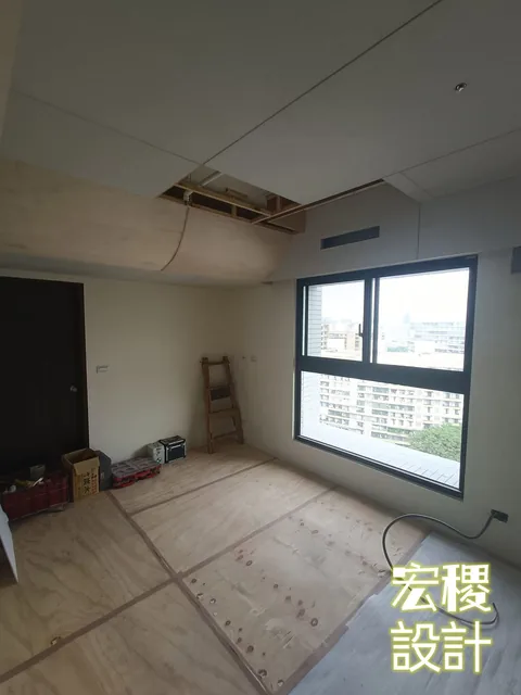 房間地面鋪設保護板，天花局部仍在施工。