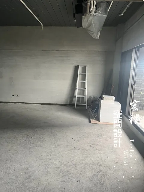 未裝飾的室內牆面、地坪與梯子等施工用品。