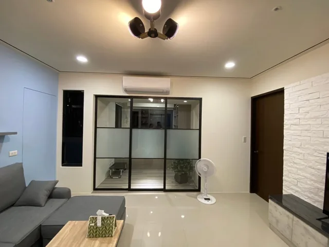 可見沙發、茶几、燈具與隔間滑門的客廳畫面。